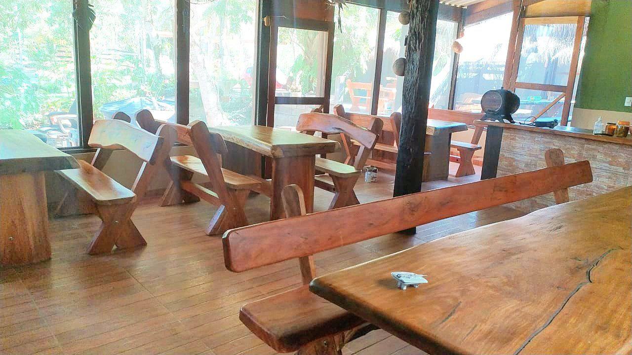 Salão com mesas de madeira maciça