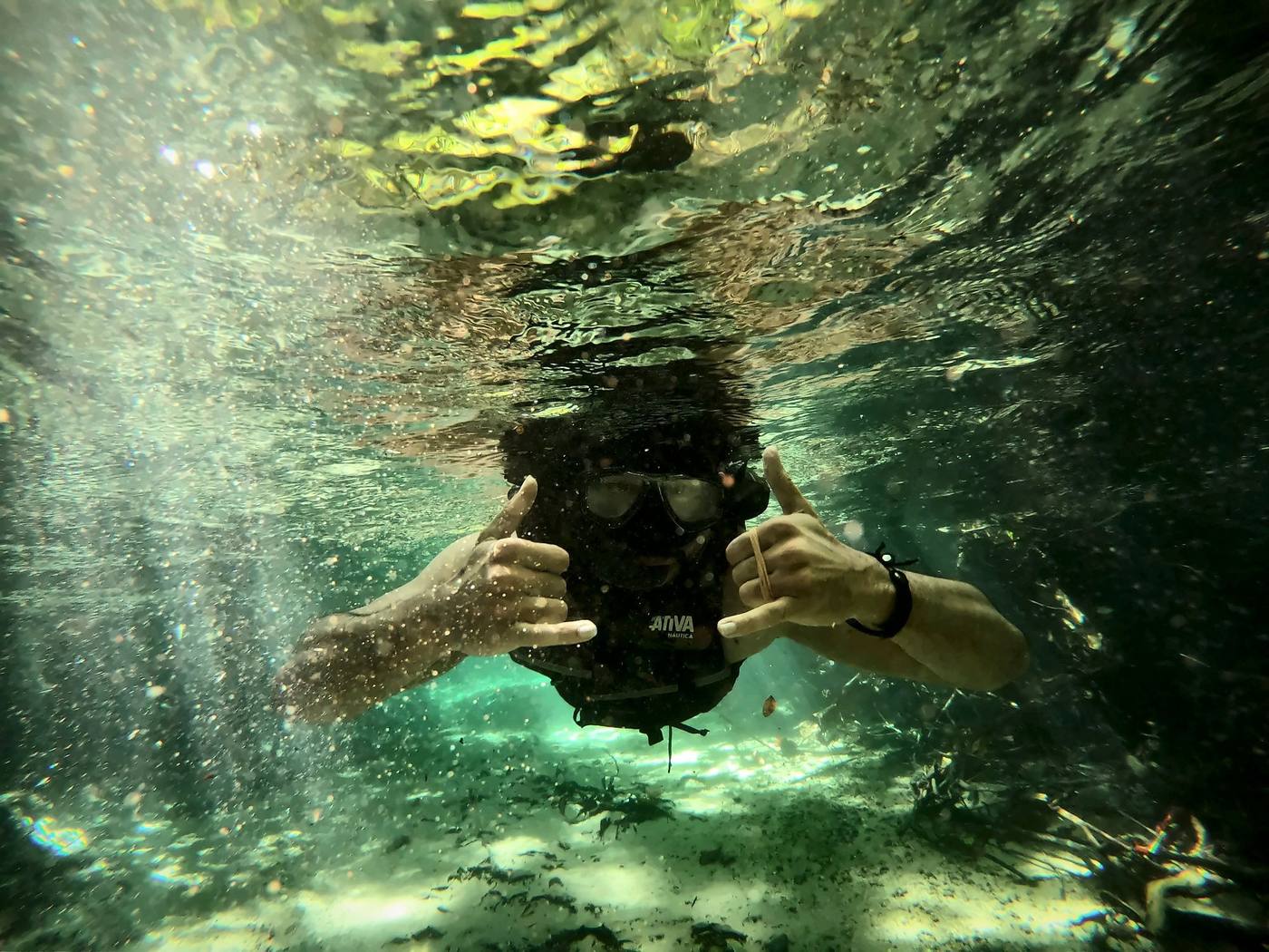 Mergulhador de snorkel acenando debaixo d'água