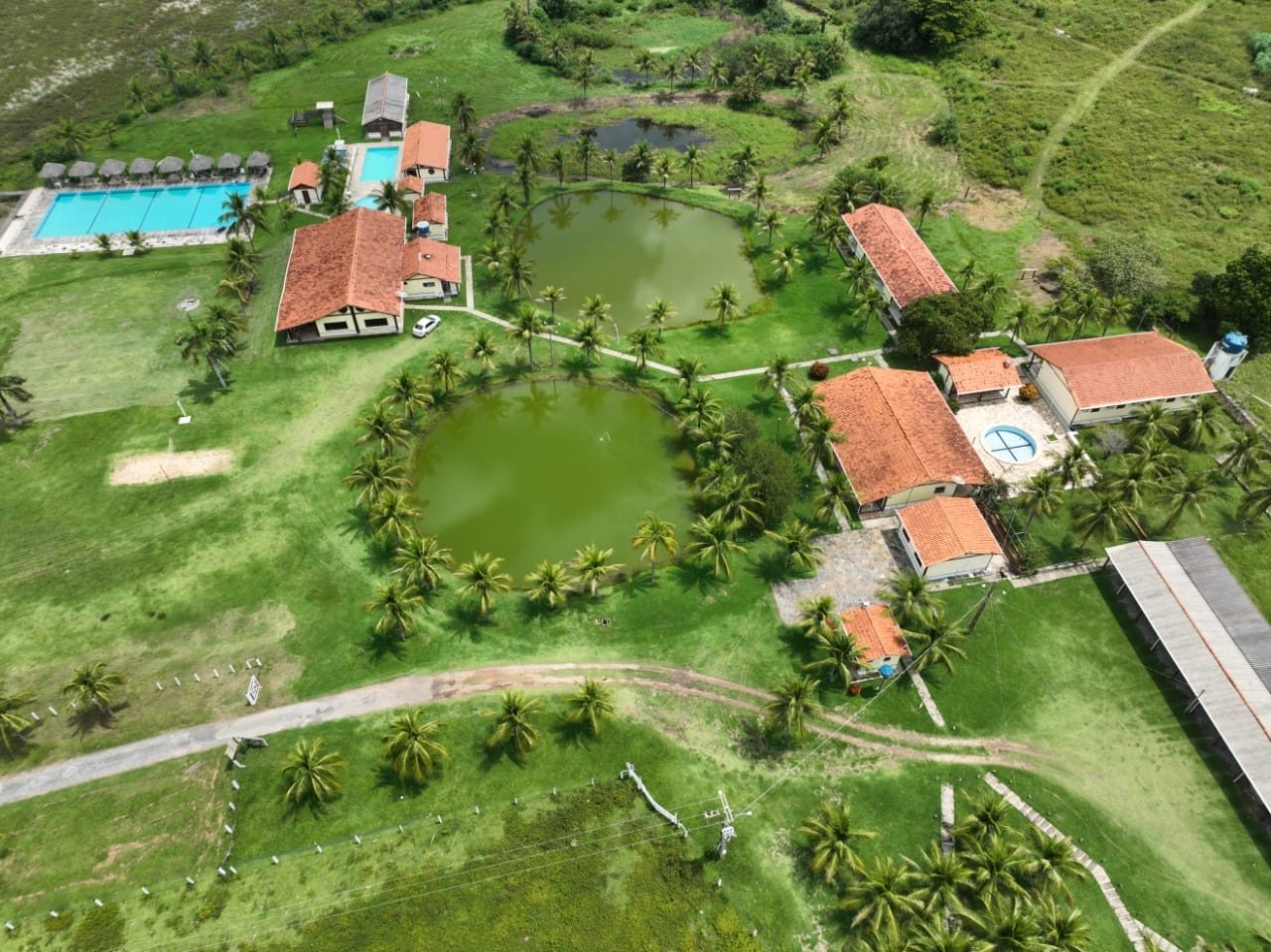 Vista aérea da pousada, com os lagos, a piscina e os chalés