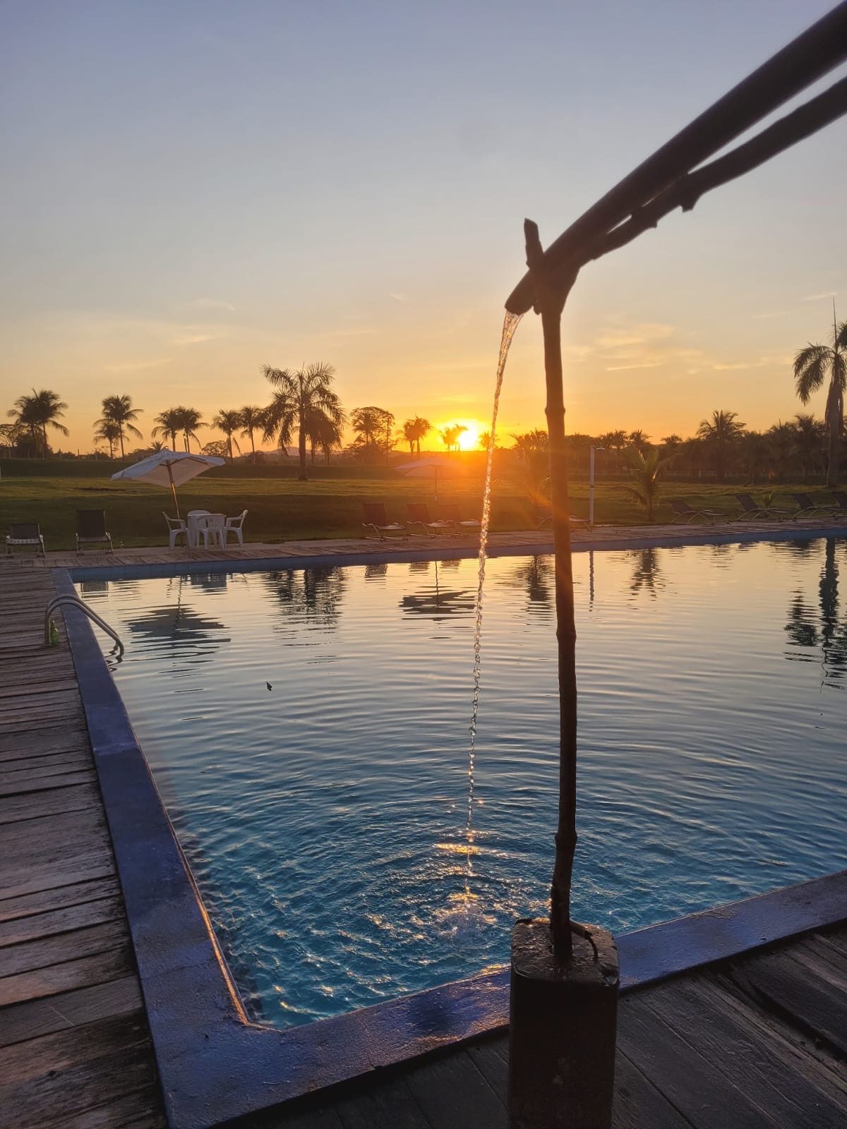 Bica de água na piscina ao pôr do sol