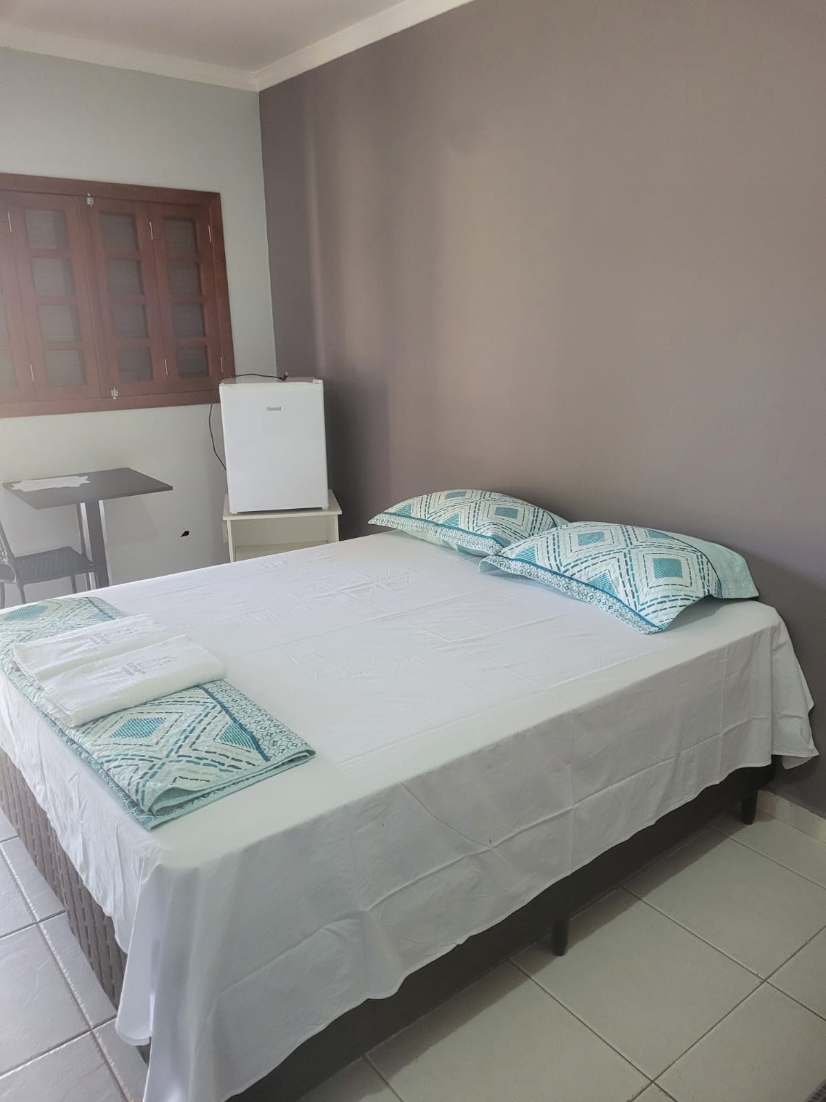 Quarto com cama de casal e frigobar