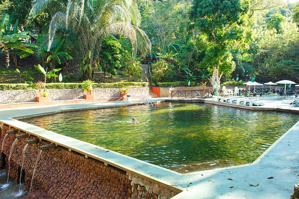 Piscina termal de águas cristalinas cercada de mata
