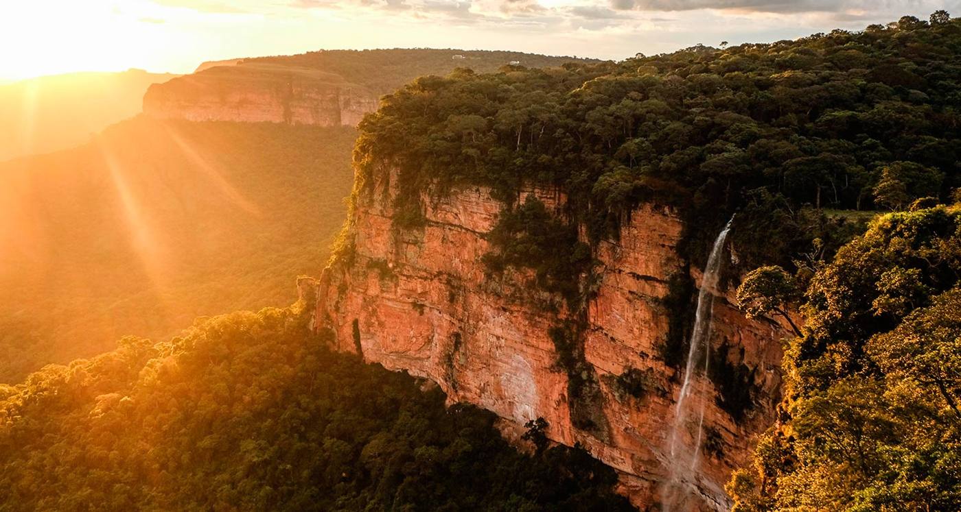 Paredões de arenito e a Cachoeira Véu de Noiva ao pôr do sol