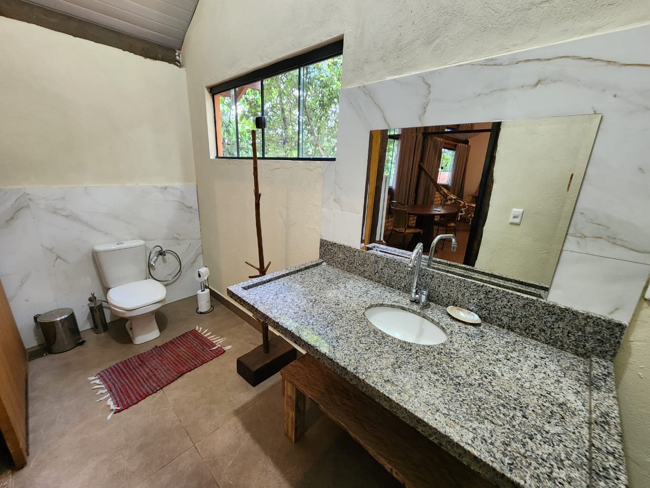 Banheiro da cabana, com janela para a mata