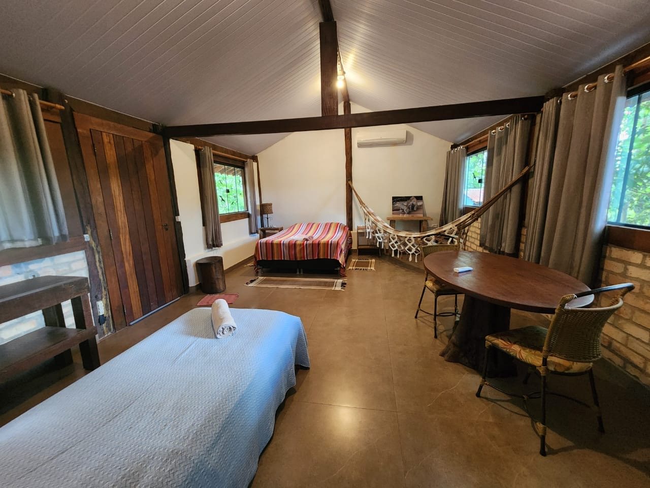 Cabana com cama de casal, cama de solteiro, rede e mesa