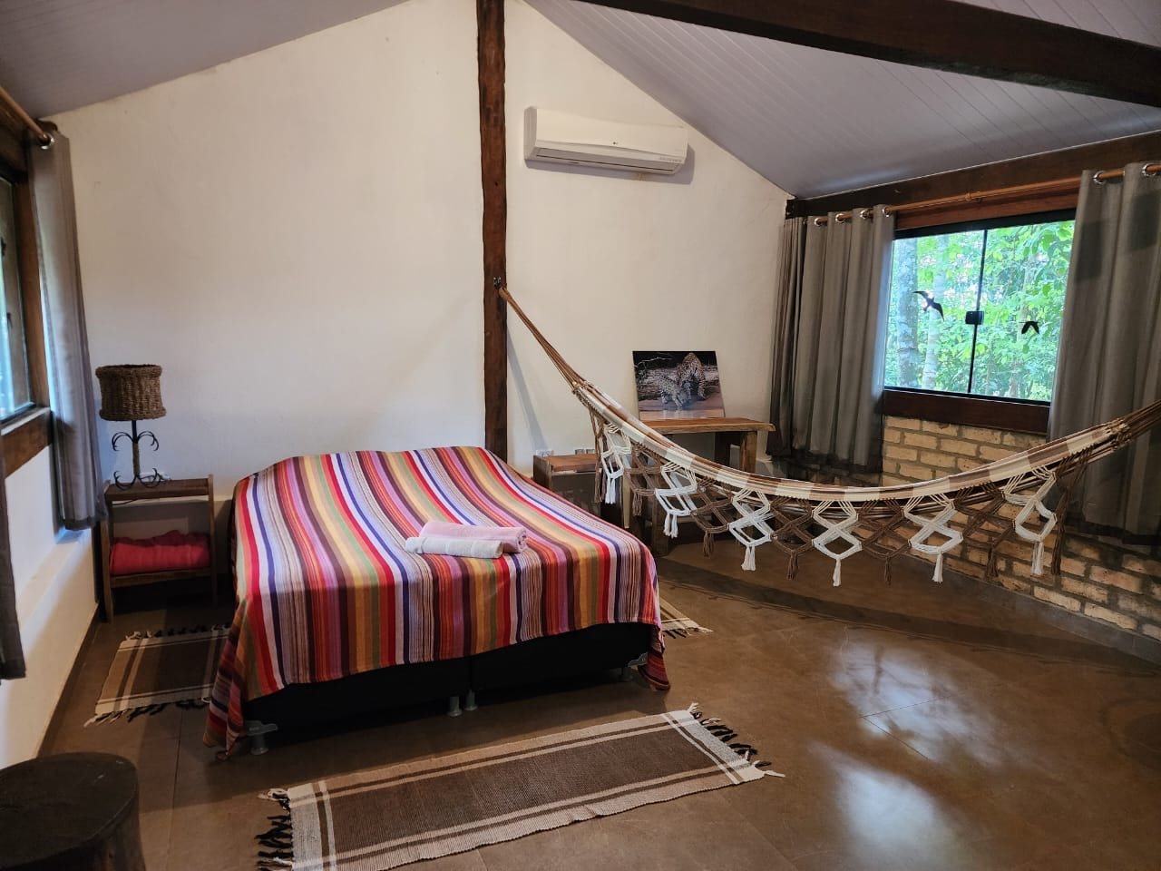 Cama de casal e rede na cabana