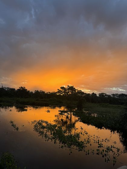 Pôr do sol laranja refletido no rio